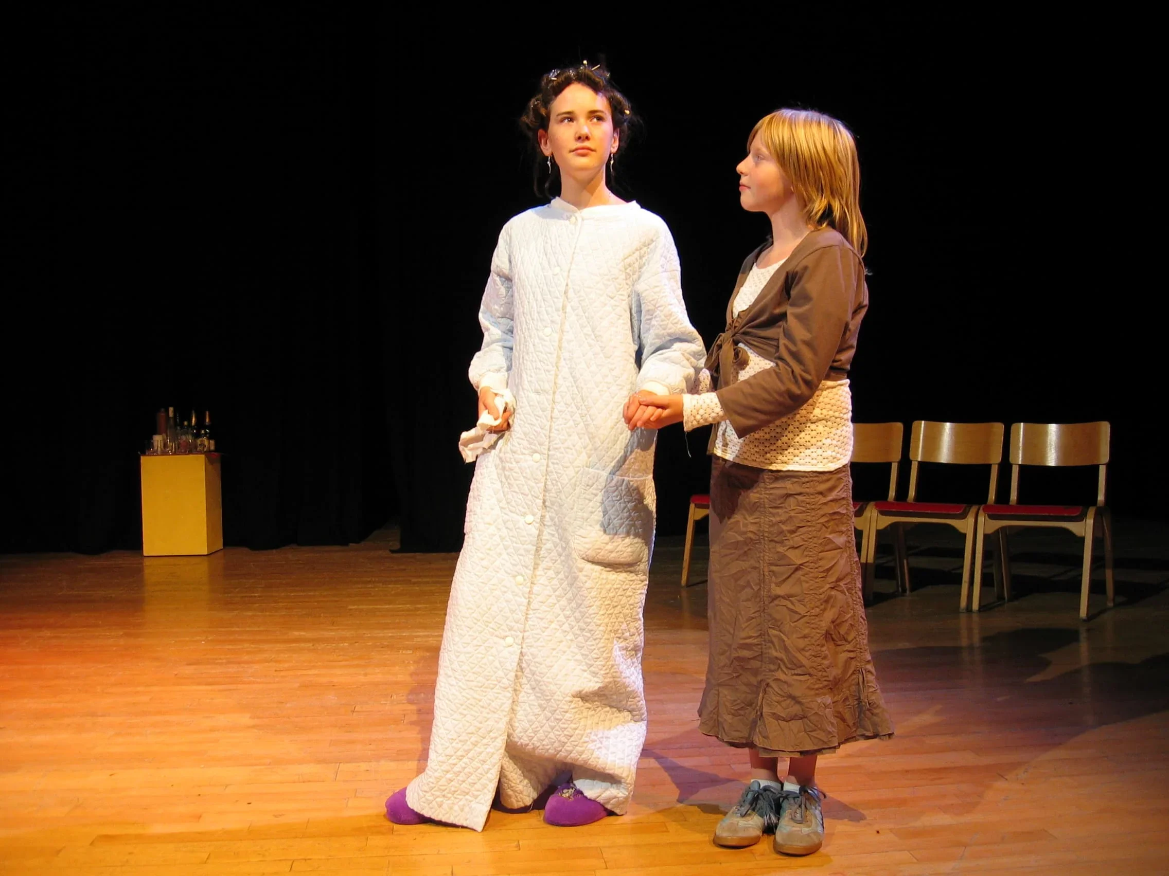 Lors de l'improvisation sur scène, une comédienne tient l'autre par le bras pour renforcer l'interaction entre les deux personnage