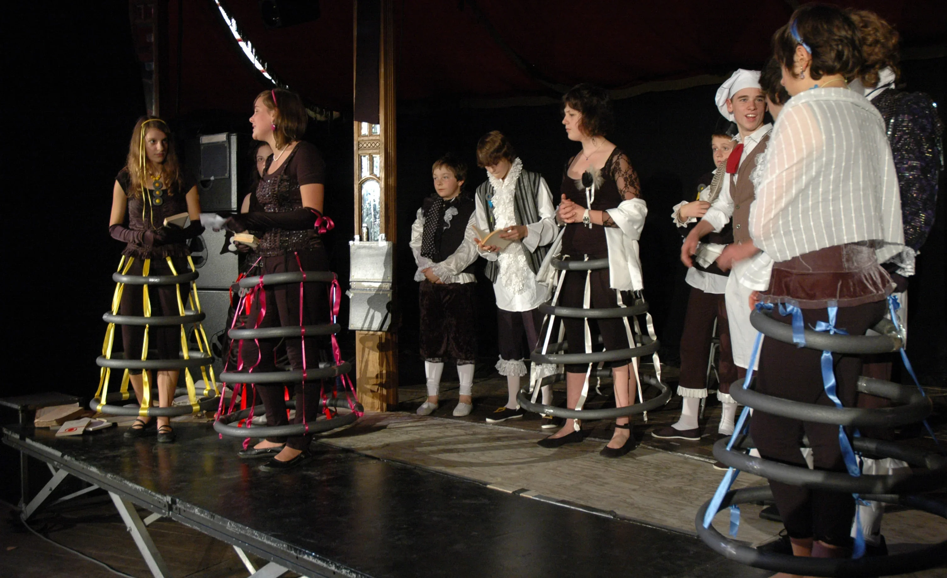 Sur scène, un groupe de jeunes comédiens répète une pièce de Molière.