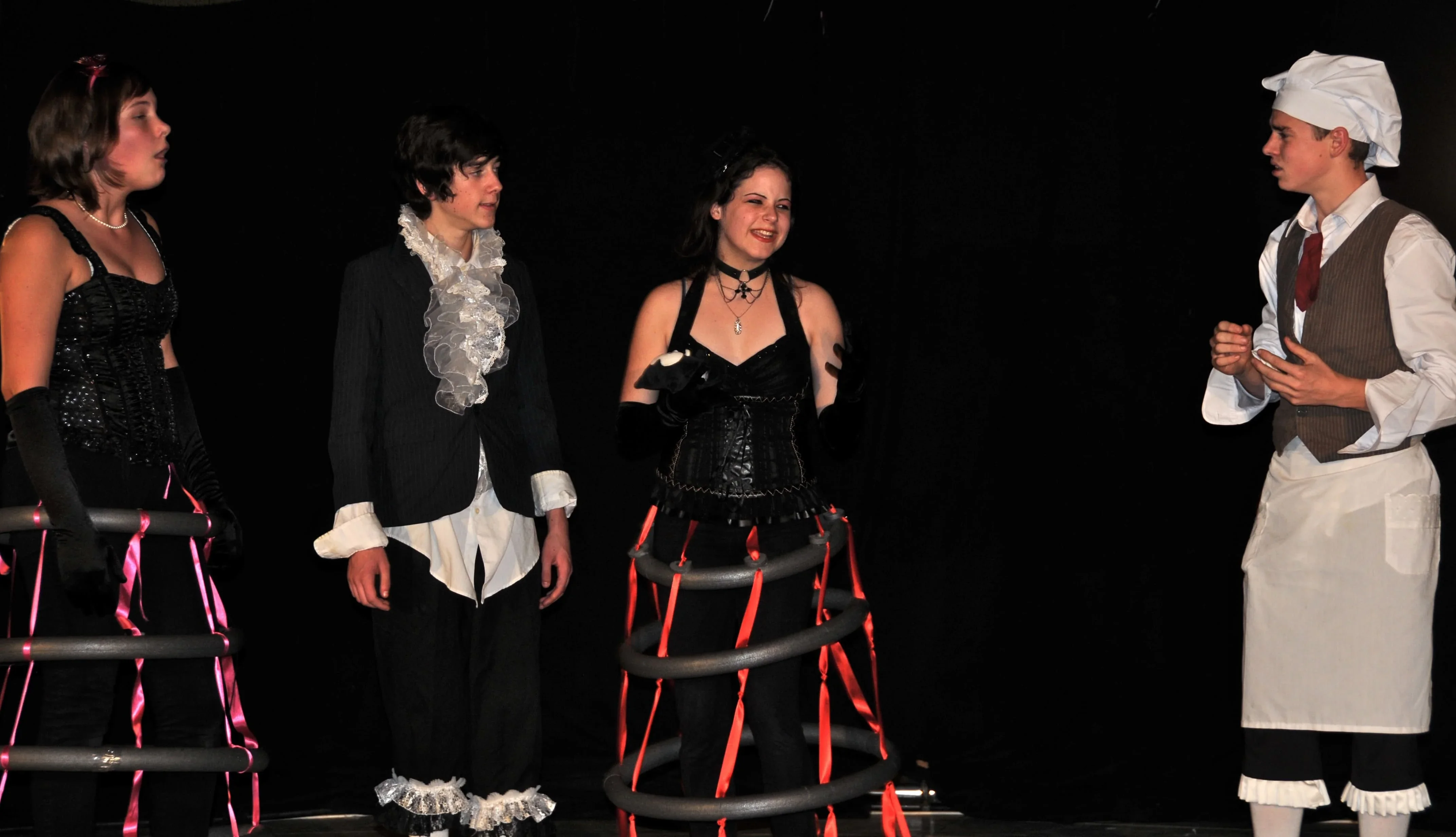 Une troupe théâtrale d'adolescents en costumes présente une scène de la pièce de Molière "Les femmes savantes".