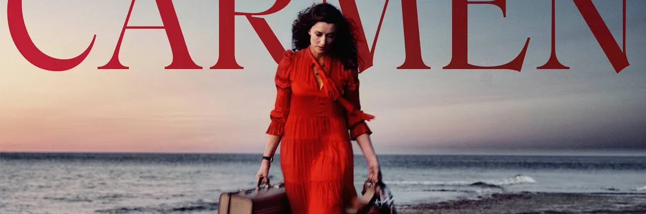 Une femme vêtue d'une robe rouge et portant une valise se promène sur la plage. En arrière-plan, la mer est visible, avec l'inscri