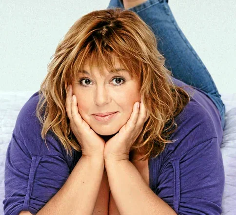 L'artiste et humoriste Michele Bernier, telle une muse envoûtante, s'étend sur le ventre, les mains délicatement posées sur son vi