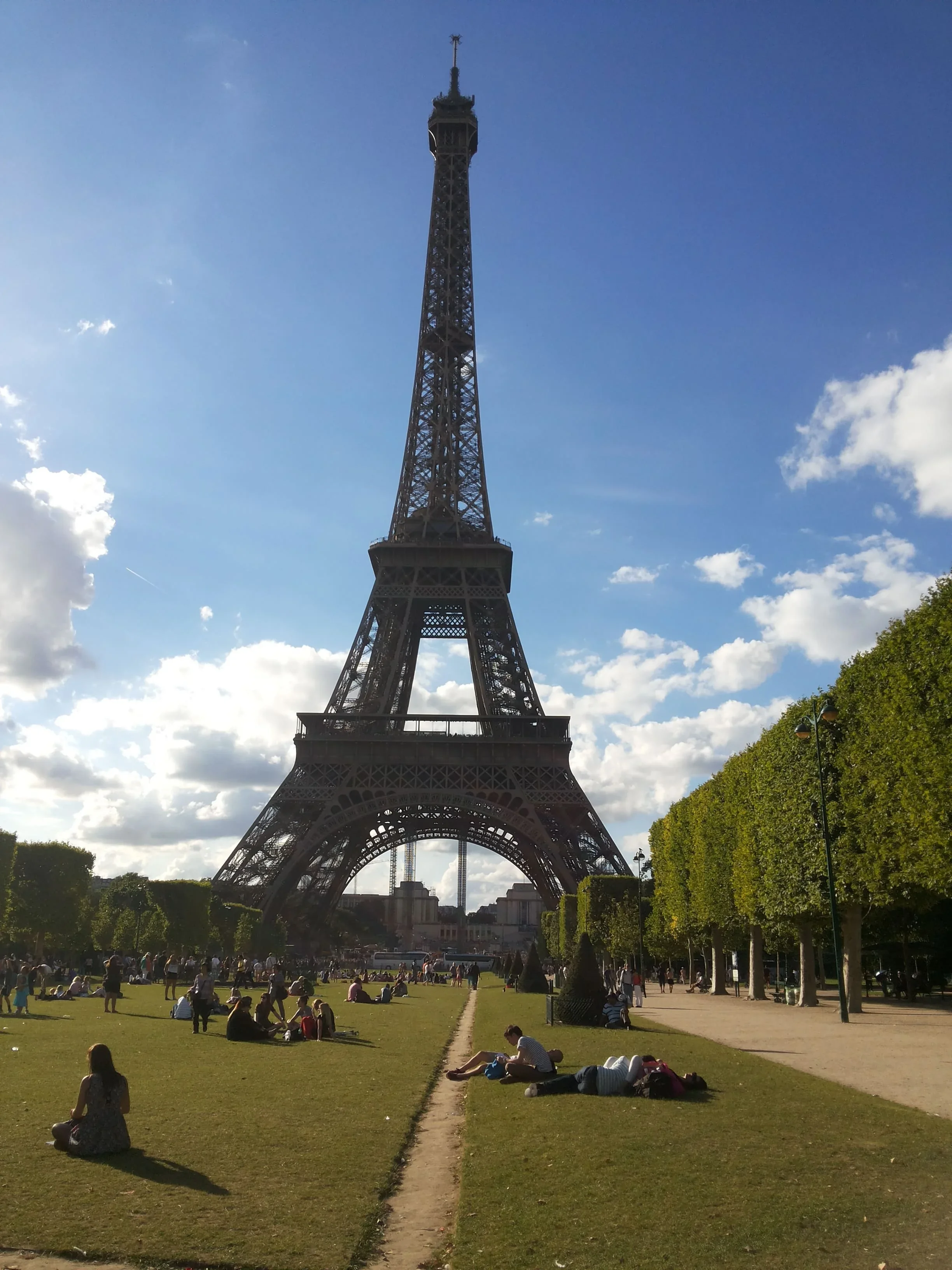 La photo représente la Tour Eiffel, majestueuse et élégante, s'élançant fièrement vers le ciel. Symbole de la ville de Paris et de