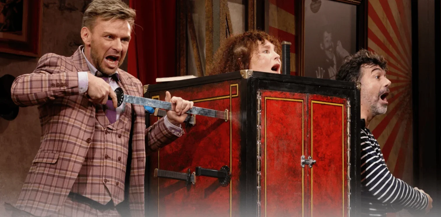 Sur scène, le magicien exécute un tour incroyable avec une boîte percée d'épées, à l'intérieur de laquelle une femme est assise. L