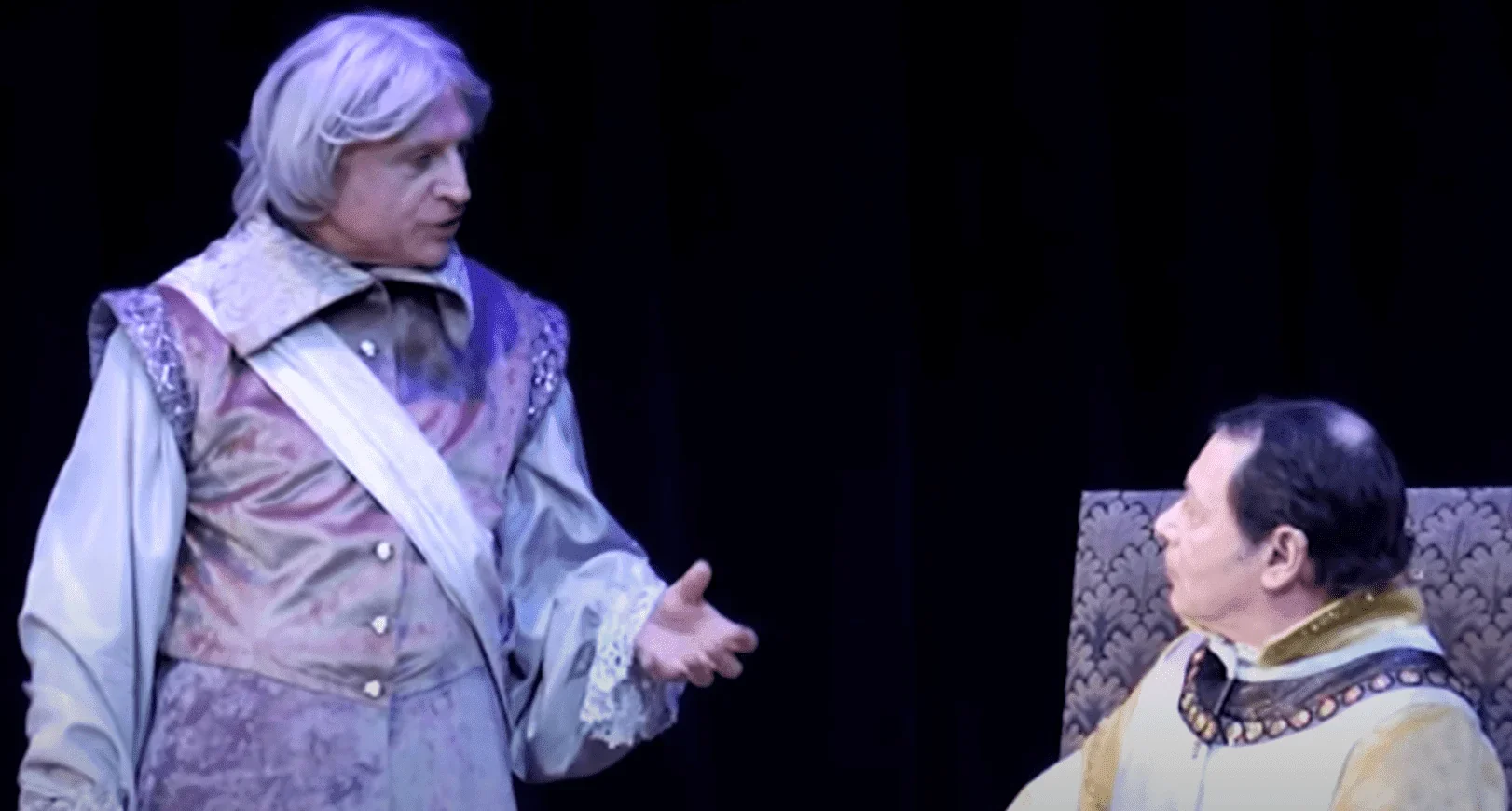 Sur scène, deux hommes incarnant les personnages de la célèbre pièce de théâtre "Le Cid" présentent un dialogue poignant, transpor