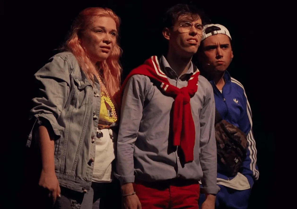 Trois comédiens sur scène, les yeux fixés sur l'horizon, contemplent l'avenir incertain qui les attend. La photo capte leur espoir