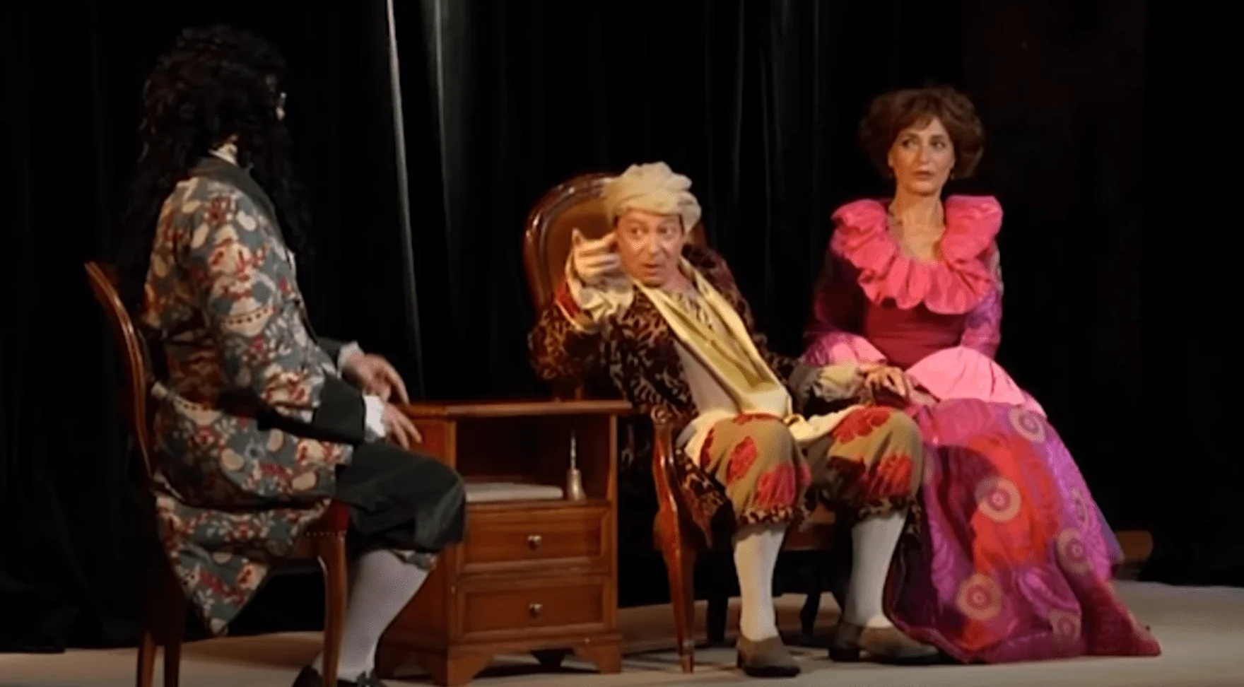 une scène de la pièce, avec Argan, le personnage principal, entouré de médecins et de charlatans qui cherchent à profiter de sa ma