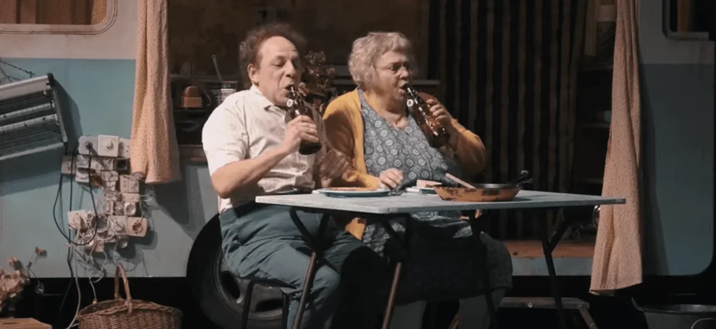 On peut voir les décors et les éclairages de la scène, ainsi que les expressions des acteurs en train de jouer leur rôle.