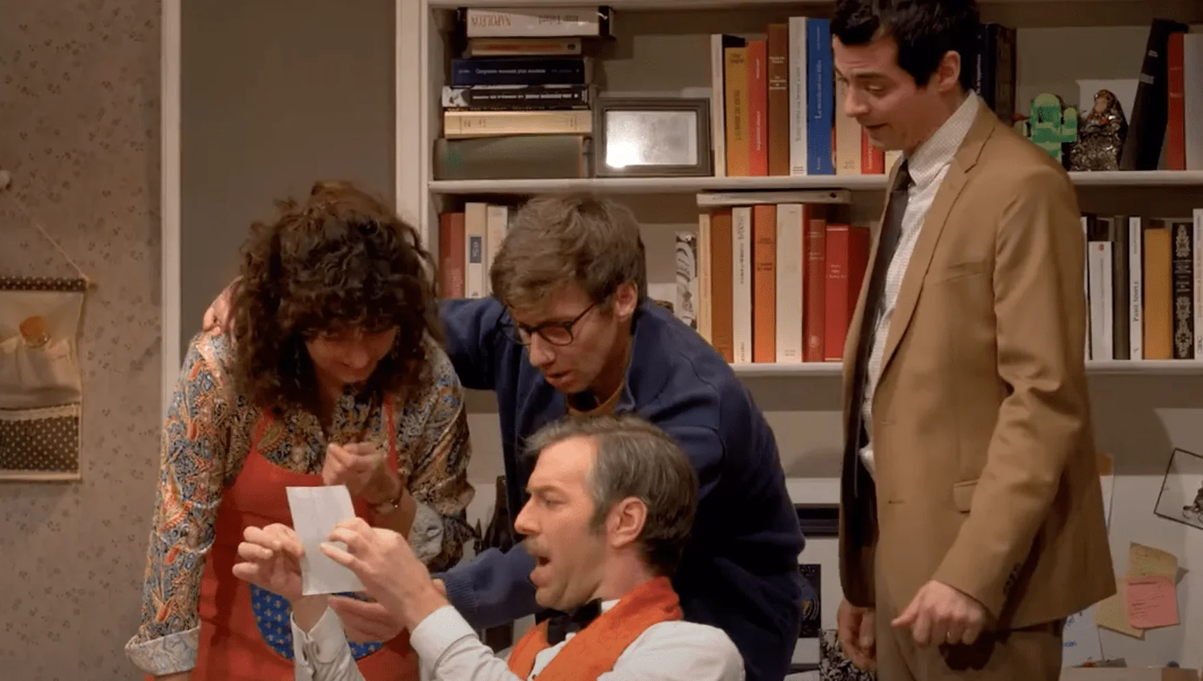 Dans cette photo, nous voyons tous les personnages de la pièce de théâtre Le Prénom réunis, en train de regarder une liste de prén