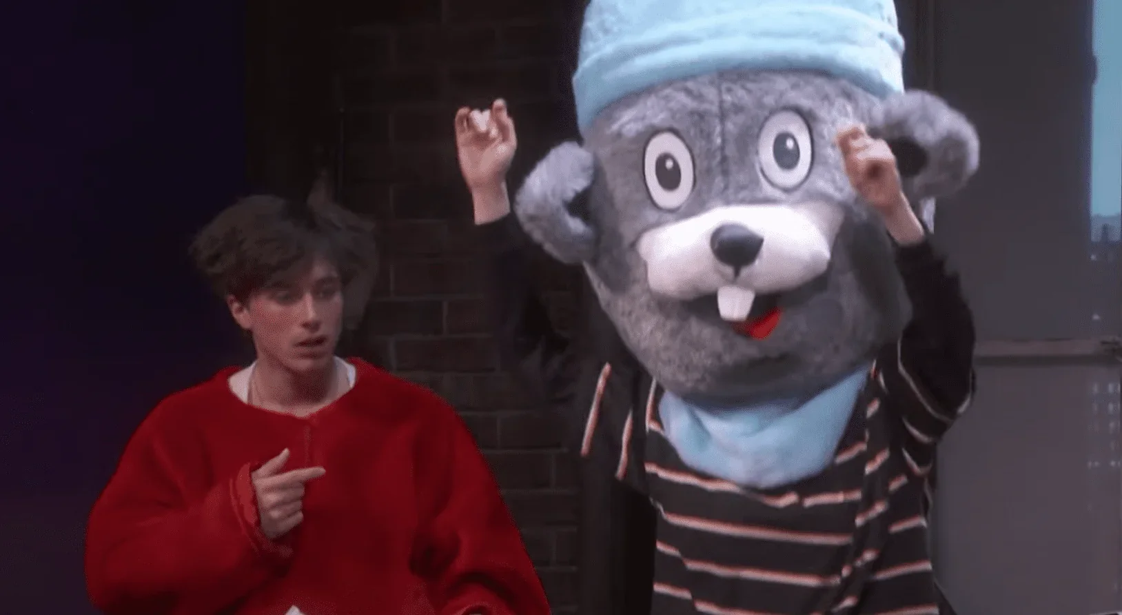 Cette photo met en avant le personnage de Tom, le petit ami de Sarah, qui découvre émerveillé la grande peluche de souris sur scèn