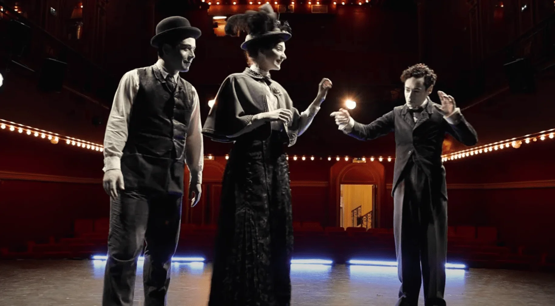 Sur scène, nous voyons les trois personnages principaux de la pièce : Grant Lawrens dans le rôle du jeune homme amoureux, Pauline