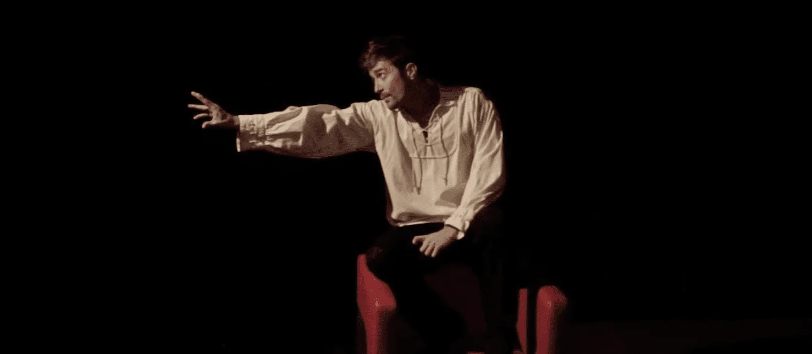 Dans cette image saisissante, nous découvrons le personnage principal du spectacle "L'Ingénu" de Voltaire, prenant la scène d'assa