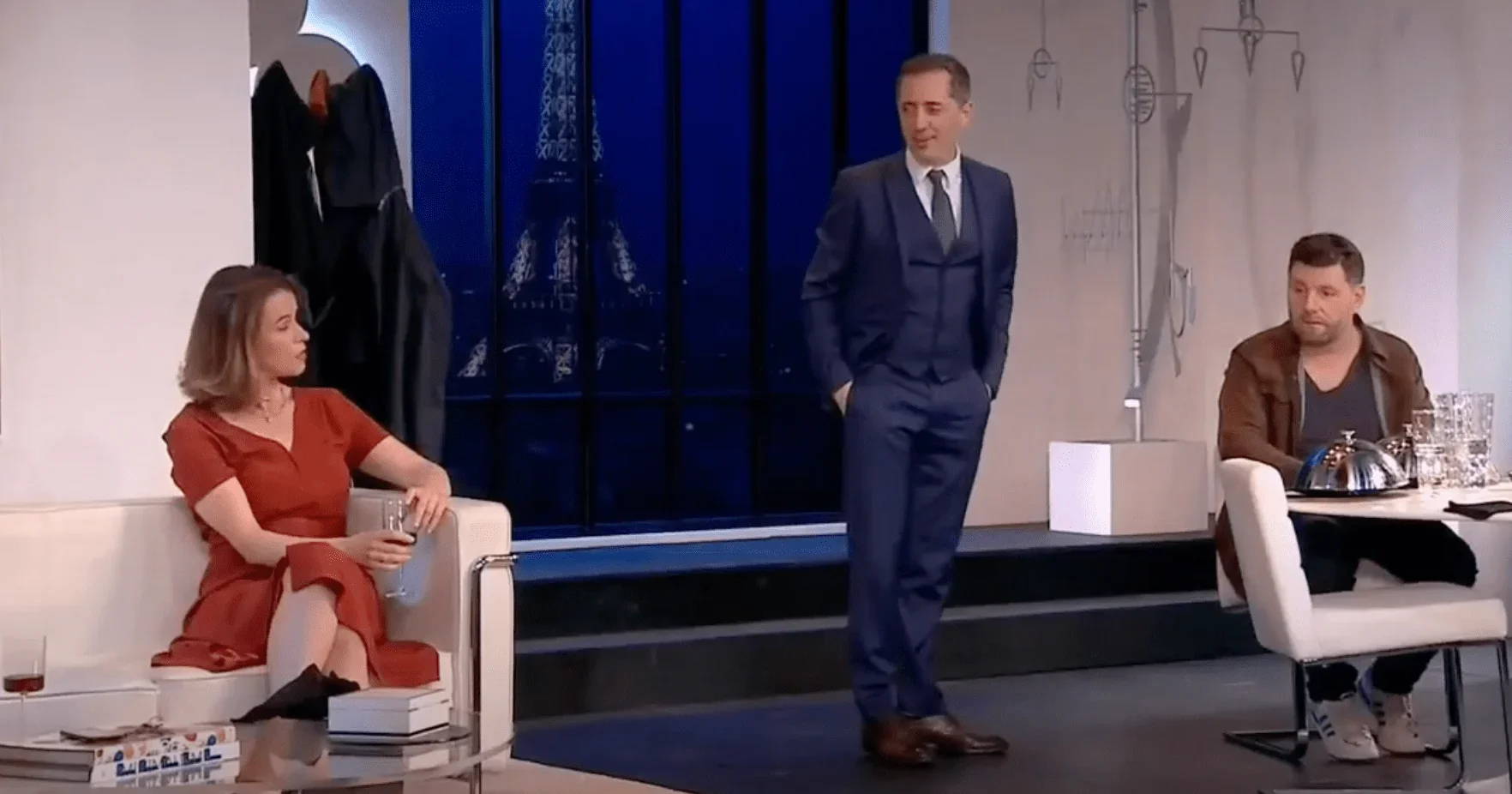 Dans cette image saisissante, nous voyons les trois acteurs principaux de la pièce de théâtre "L'invitation" sur scène. Patrick Ch