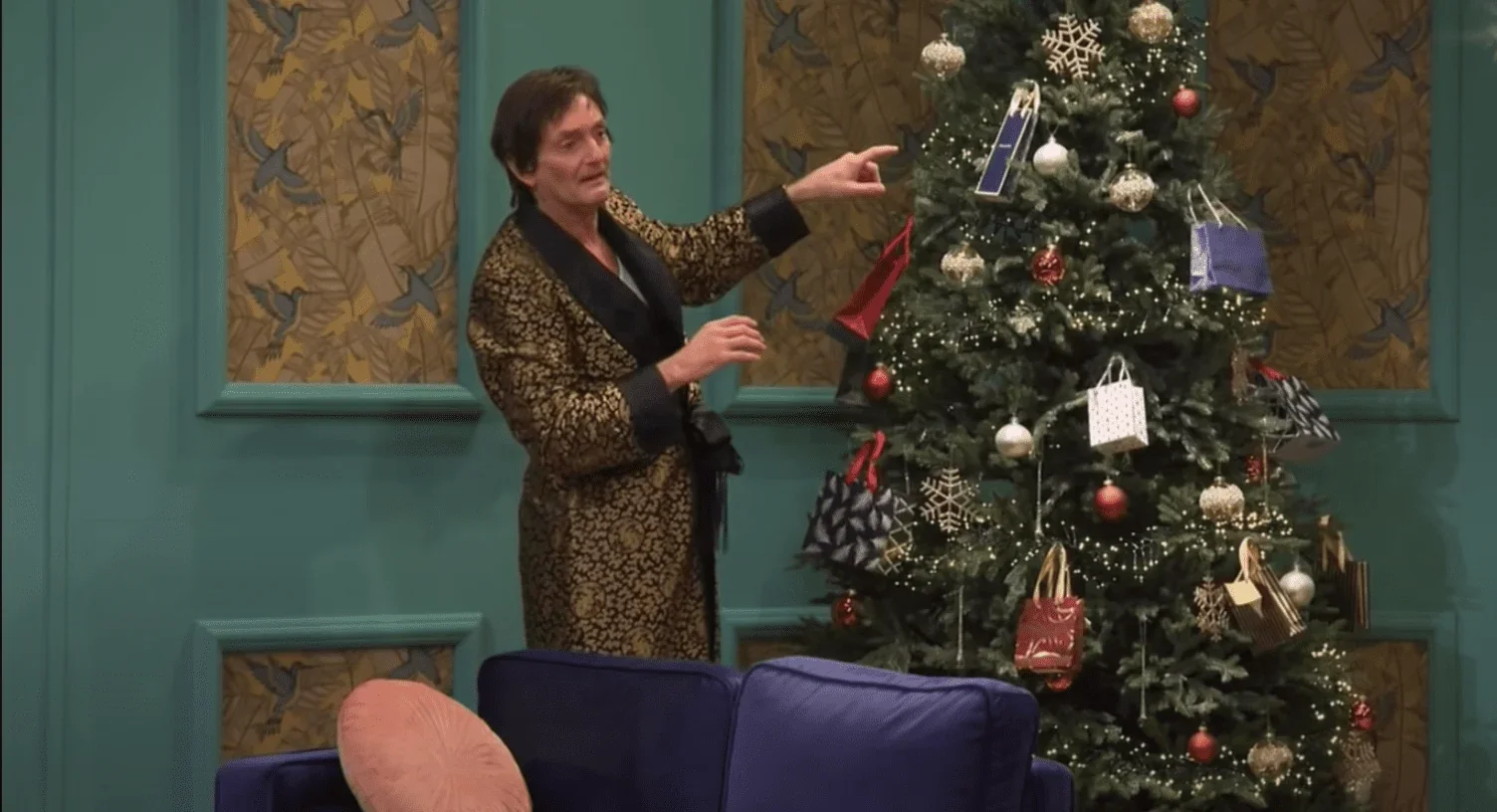 Cette image saisissante nous transporte dans une scène chaleureuse près d'un sapin de Noël dans la pièce de théâtre "13 à table" é