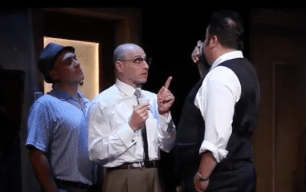 L'image saisissante présente une scène clé du spectacle "12 hommes en colère" où trois jurés engagent une discussion passionnée.