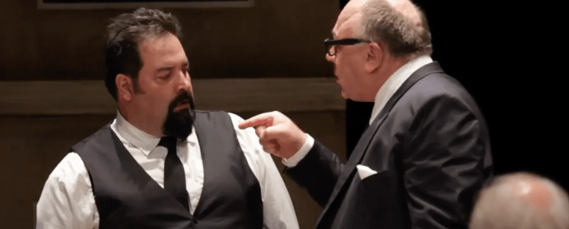 L'image saisissante met en évidence une scène mémorable du spectacle "12 hommes en colère" où deux jurés se disputent ardemment.