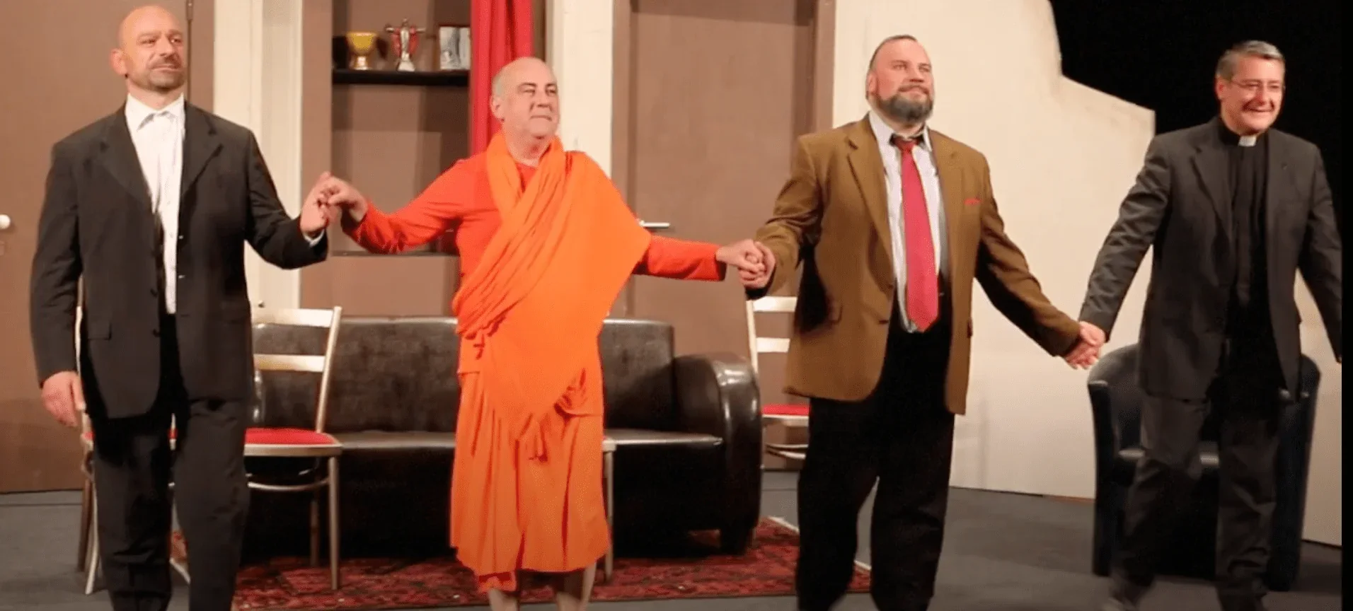 L'image capture le moment des saluts finaux du spectacle, où les acteurs se réunissent sur scène pour saluer le public.