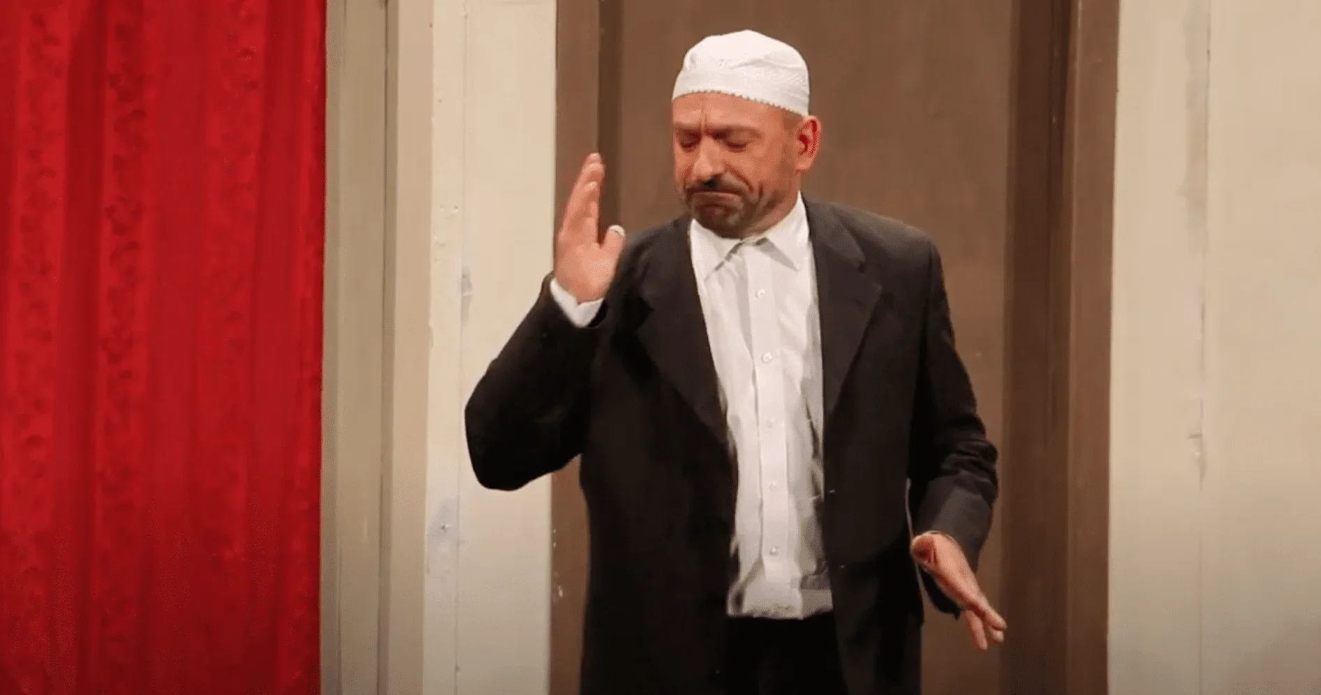 L'image met en scène un imam assis dans une posture méditative, plongé dans une profonde réflexion.