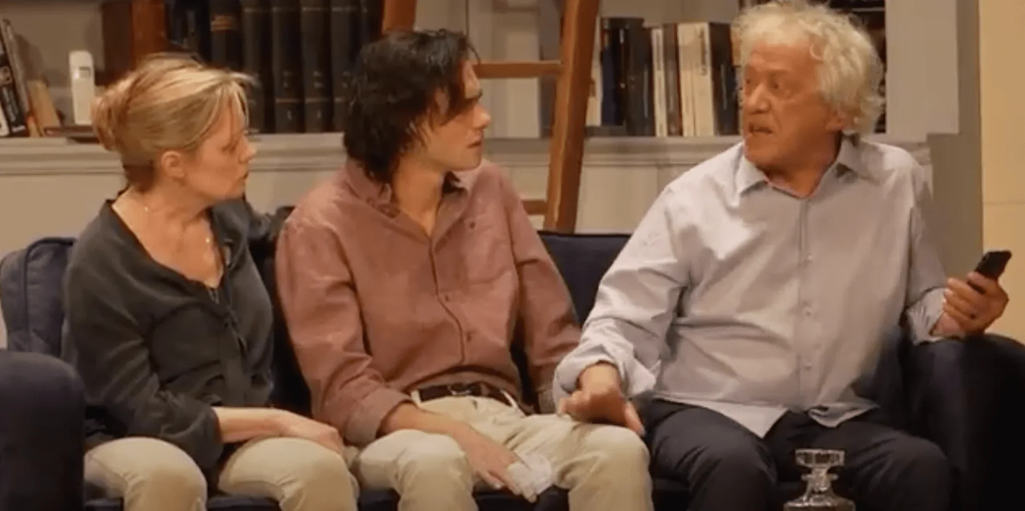 L'image met en scène une famille assise ensemble sur un canapé dans la pièce de théâtre "Inavouable".