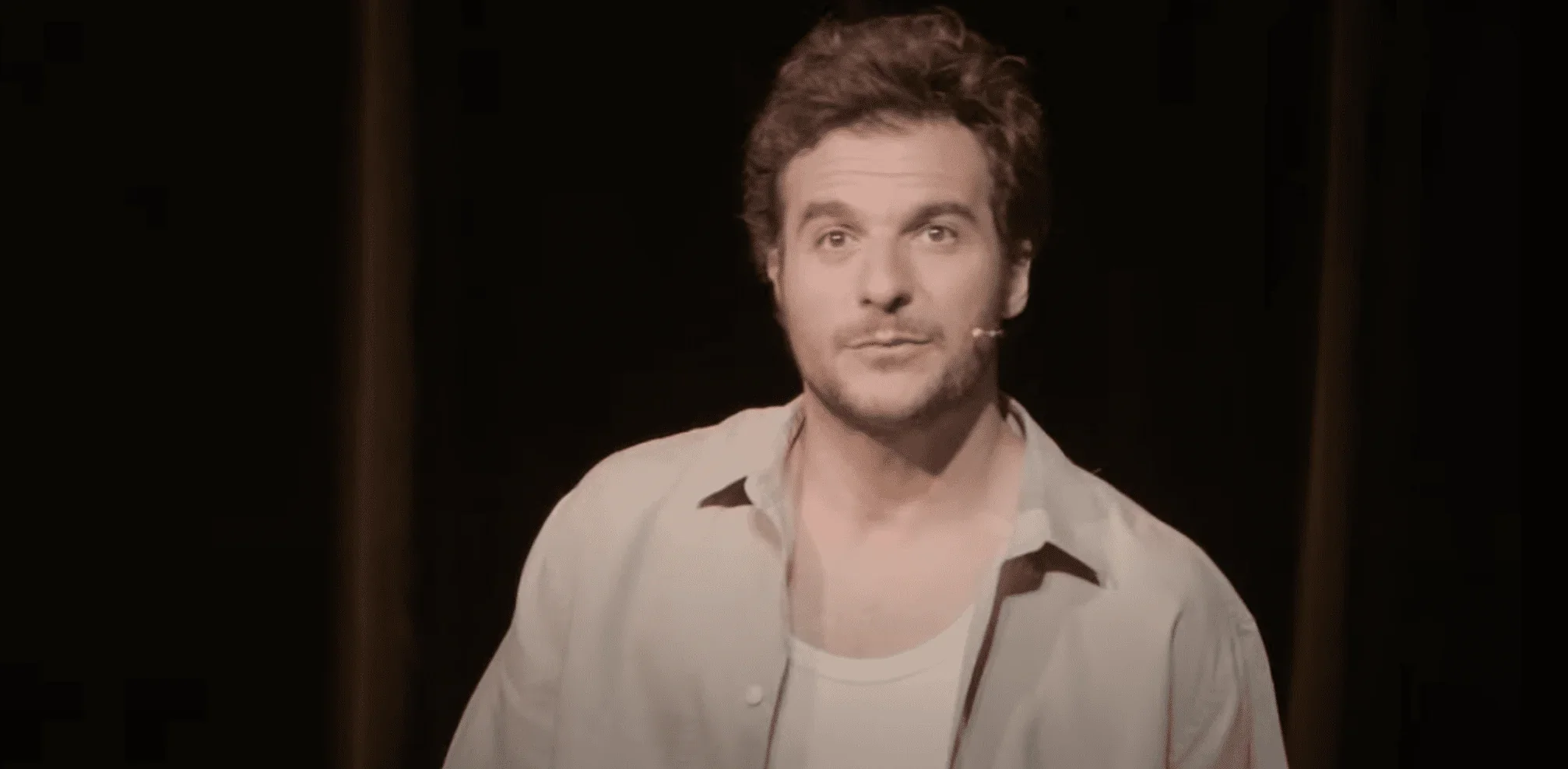 Dans cette photo capturée lors de la pièce de théâtre "Sélectionné", nous voyons Amir Haddad sur scène, captivant le public avec s