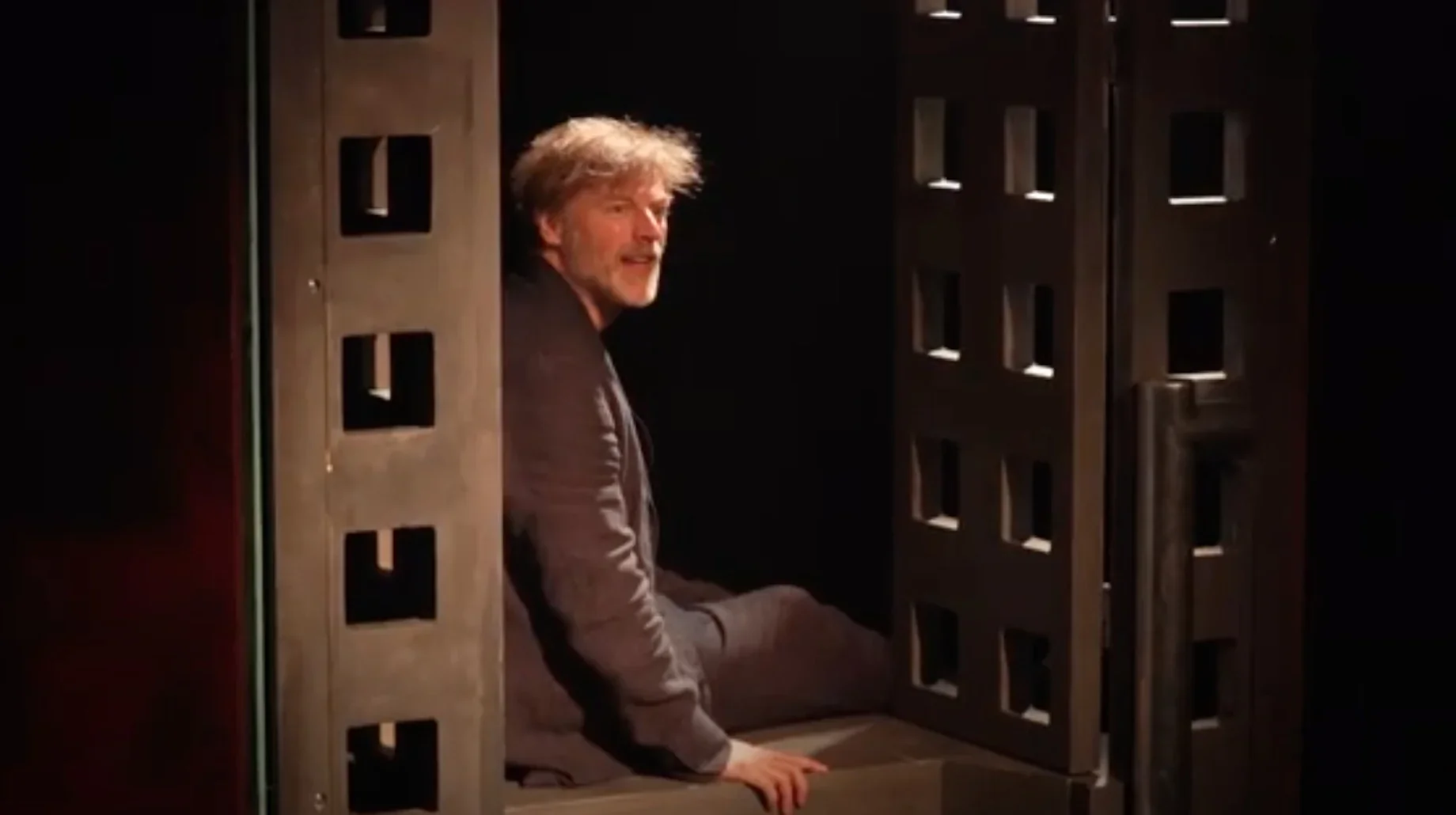 Au premier plan, Marcello, éclairé d'une lumière douce et mélancolique. Son regard est fixe et déterminé, imprégné d'un mélange de