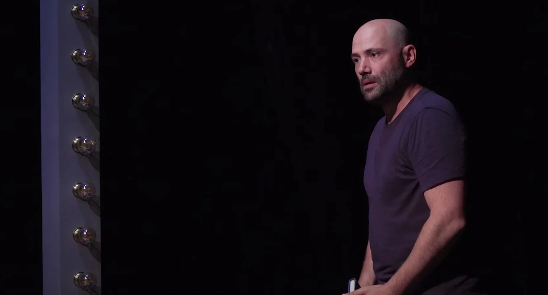 Cette image présente Julien Seul, un personnage clé de la pièce "Changer l'Eau des Fleurs", plongé dans une profonde réflexion. So