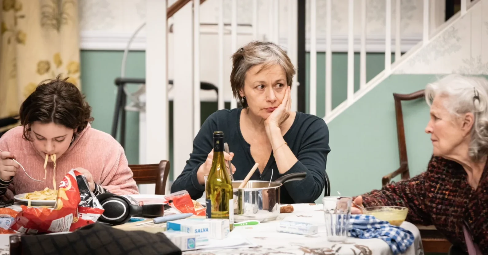 Cette image saisit un instant de profonde intimité partagée autour d'une table, où les personnages d'Alice et de ses proches se ra