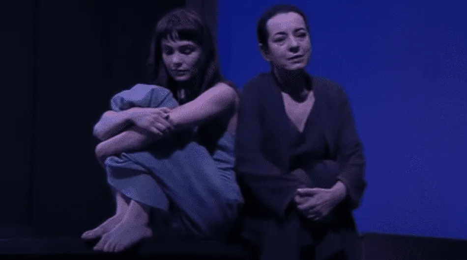 Les deux femmes se tiennent debout, chacune en train de regarder dans une direction différente, illustrant la tension et la distan