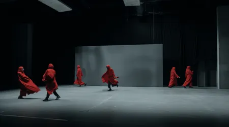 Groupe d'artistes en costumes rouges sur scène en train d'improviser