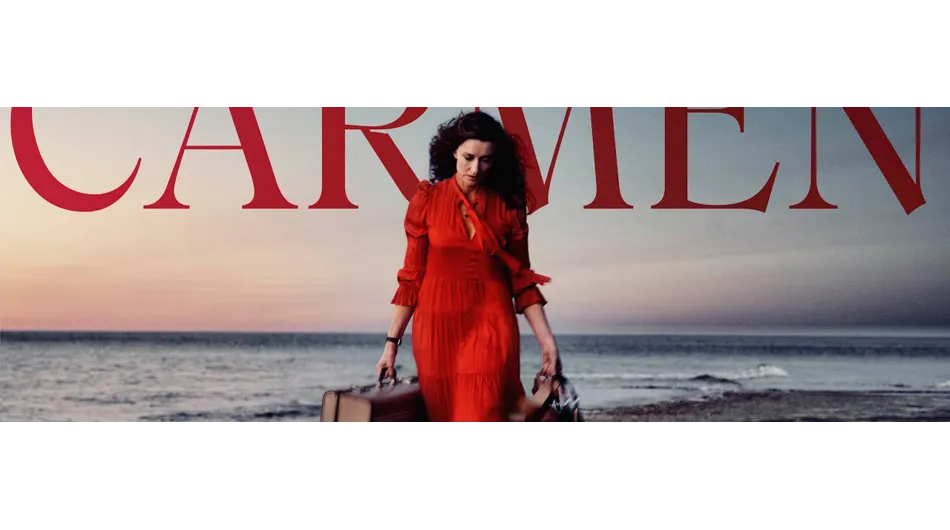 Une femme vêtue d'une robe rouge et portant une valise se promène sur la plage. En arrière-plan, la mer est visible, avec l'inscri